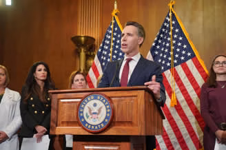 Senator Josh Hawley Introduces Bill to Ban Abortion Pills Man speaking at a podium with American flags in the background