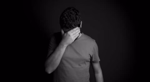 Man with hand over face appears to be sad